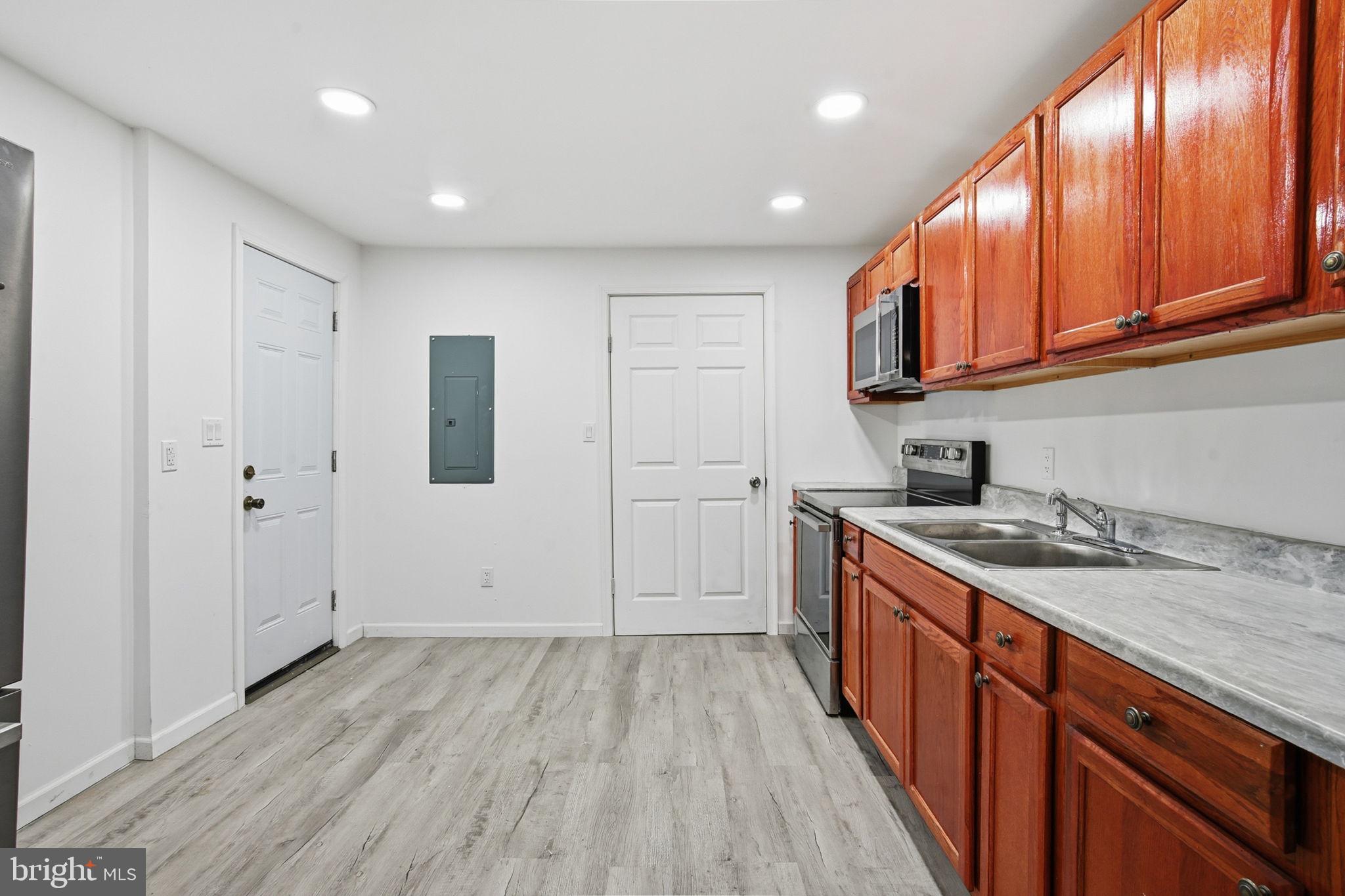 603 Academy Street Cambridge, MD 21613 - Photo 6 of 22 a kitchen with a sink window and cabinets