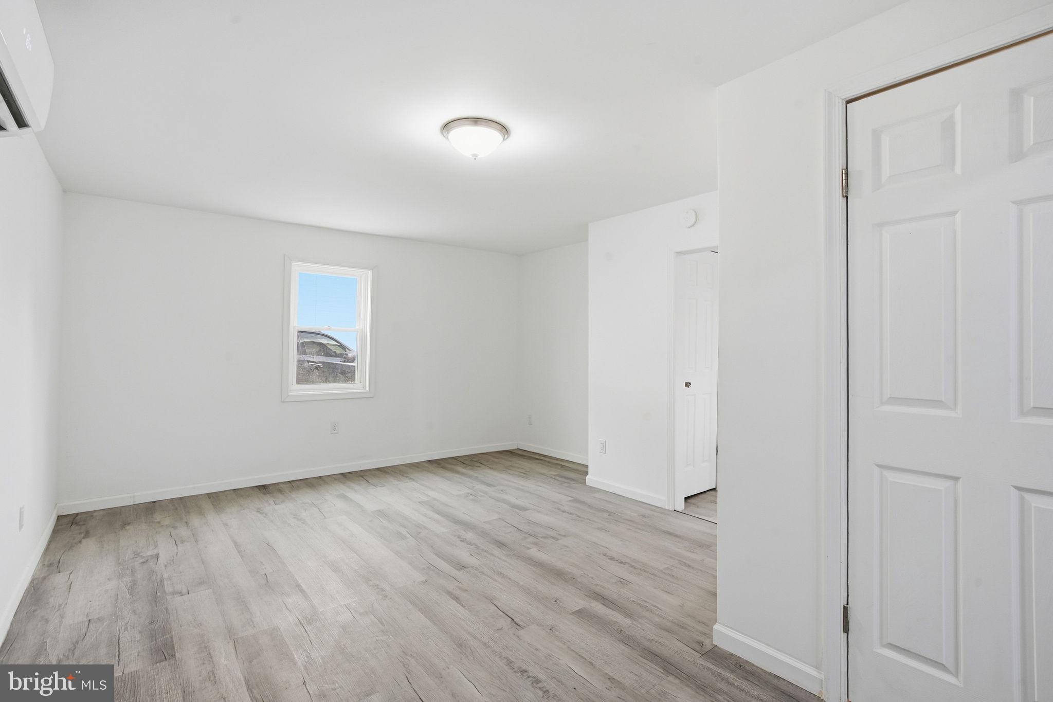 603 Academy Street Cambridge, MD 21613 - Photo 8 of 22 an empty room with wooden floor and windows
