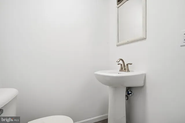 a bathroom with a sink mirror and toilet