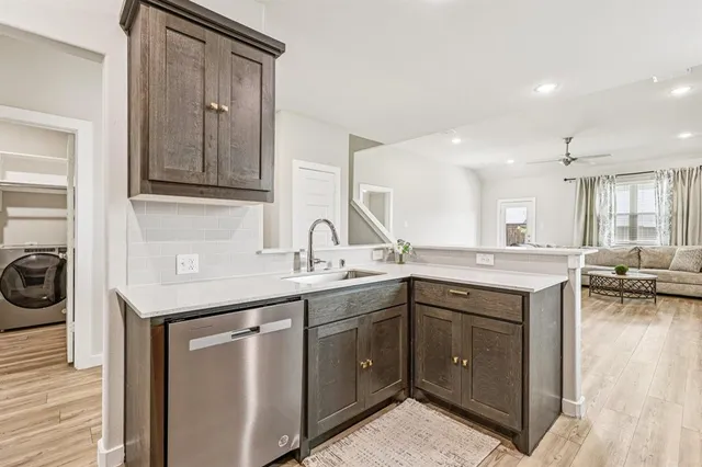a view of kitchen dining space with wooden floor stainless steel appliances and a window
