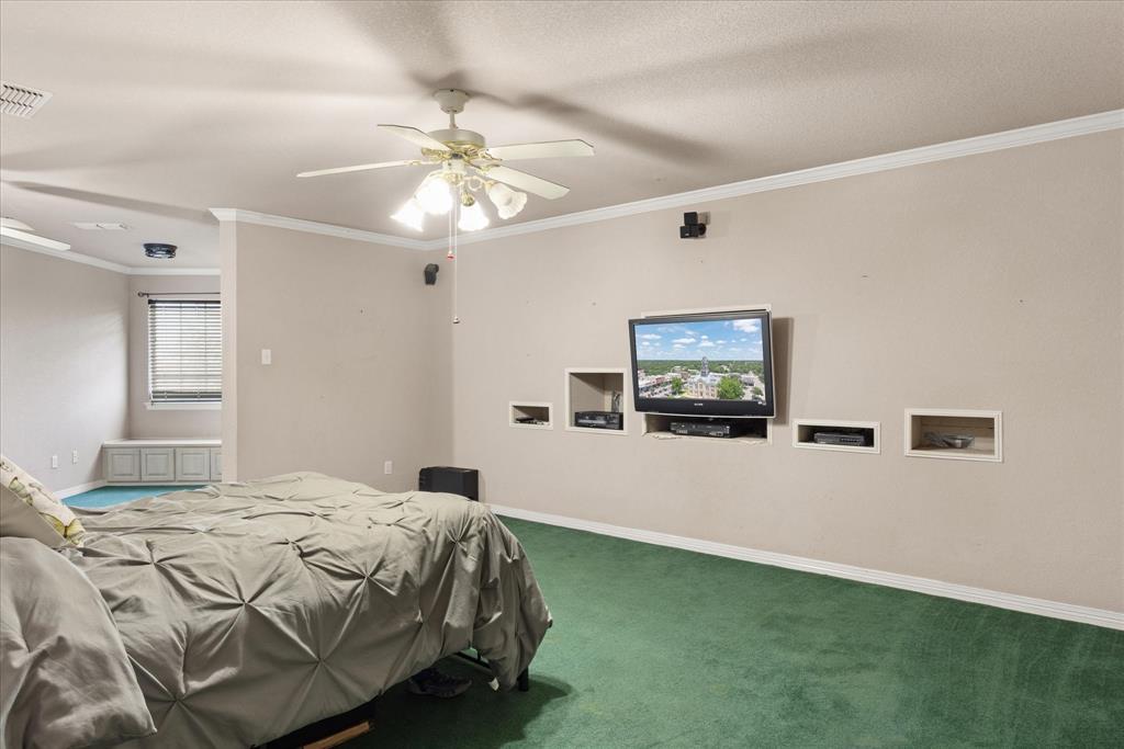 1636 Greenview Court Aledo, TX 76008 - Photo 12 of 30 a bedroom with a bed and a chandelier