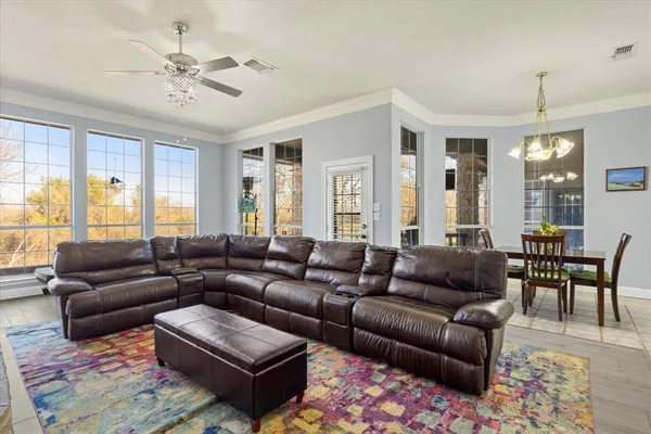 a living room with furniture ceiling fan and a window