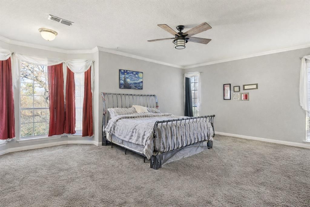 1636 Greenview Court Aledo, TX 76008 - Photo 15 of 30 a bedroom with a bed and a chandelier