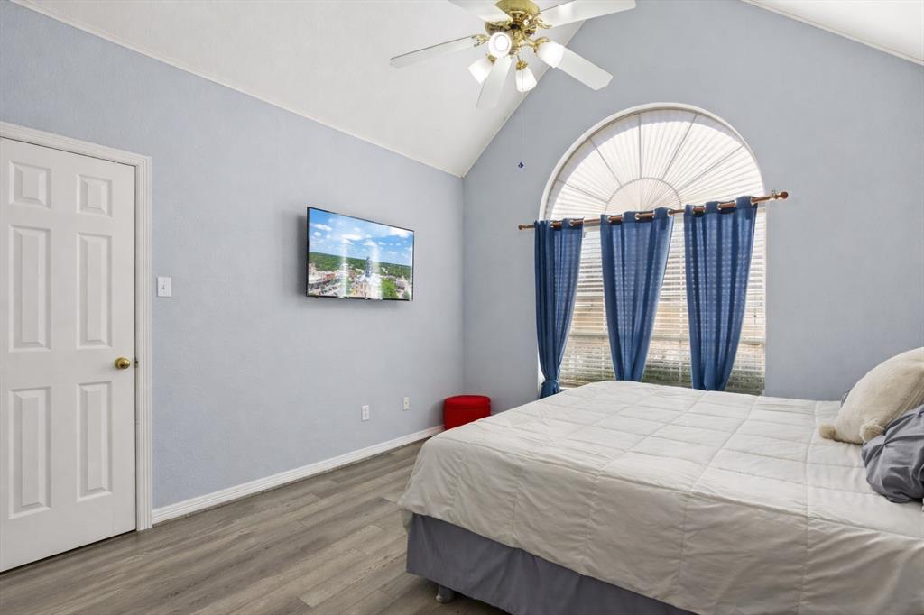 1636 Greenview Court Aledo, TX 76008 - Photo 17 of 30 a bedroom with a bed and a chandelier