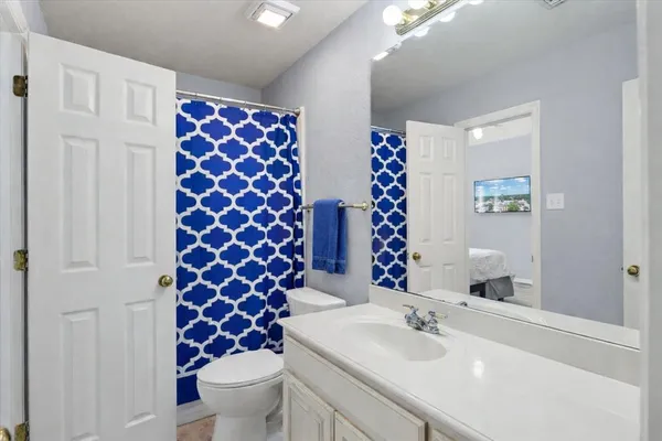 a bathroom with a sink a toilet and shower curtain