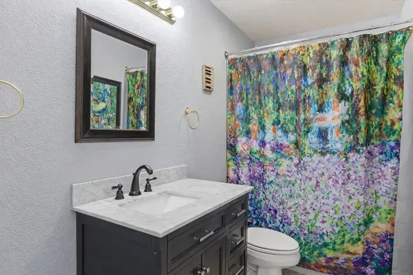 a bathroom with a toilet sink and mirror