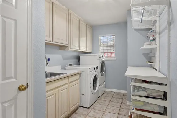 a utility room with cabinets washer and dryer