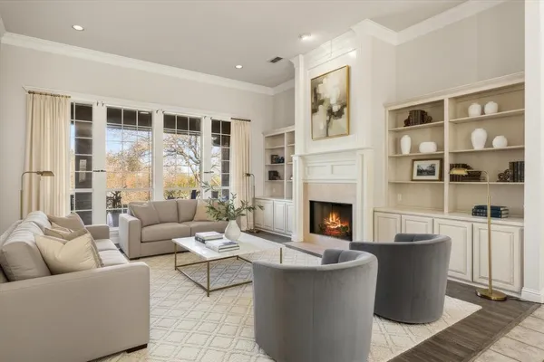 a living room with furniture a fireplace and a large window