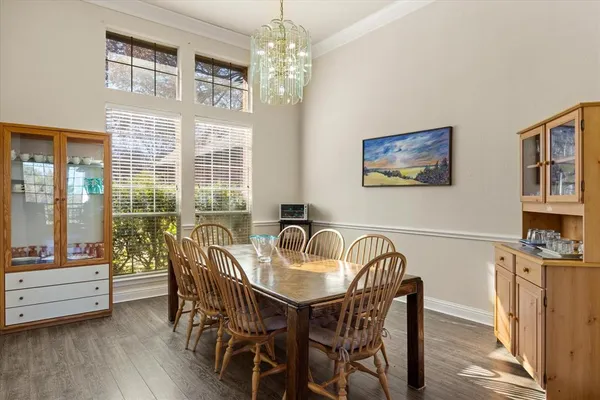 a dining room with furniture a chandelier and wooden floor
