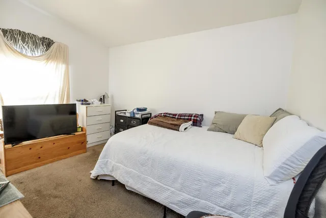 a bedroom with a bed and flat screen tv