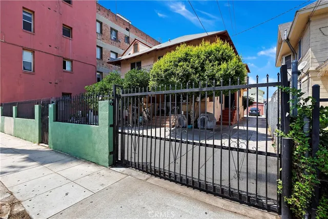a view of a house with a small yard and wooden fence