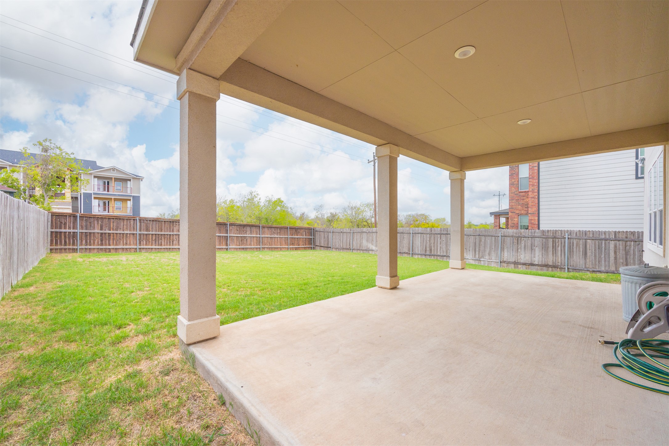 7009 Nutria Run Austin, TX 78744 - Photo 14 of 15 A spacious covered patio overlooks a private, grassy yard, fully fenced for outdoor enjoyment.