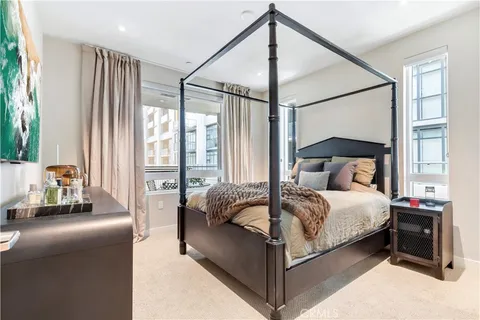 a bedroom with a bed and large windows