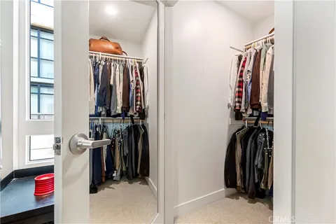 a view of walk in closet with clothes and shoes