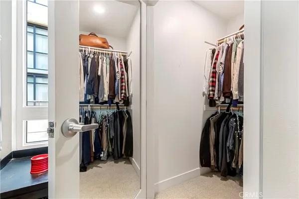 a view of walk in closet with clothes and shoes