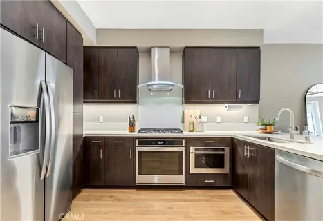 a kitchen with stainless steel appliances granite countertop a stove a refrigerator and a sink