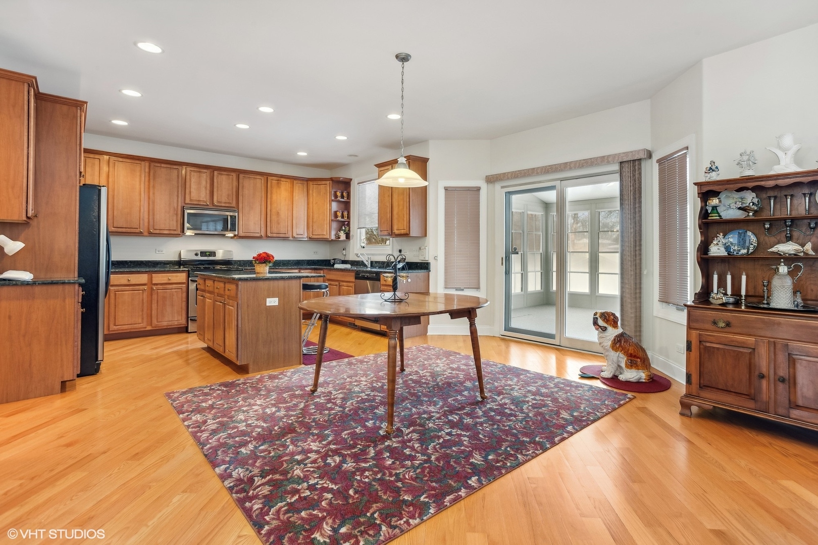 1034 East Woodrow Avenue Lombard, IL 60148 - Photo 8 of 36 a kitchen with stainless steel appliances granite countertop a stove top oven a sink and a dining table with wooden floor