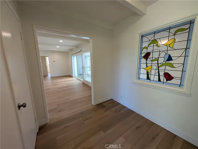 a view of an empty room with glass door and windows