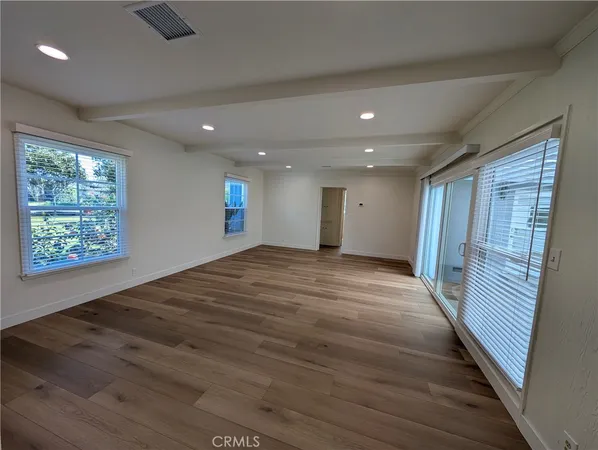 a view of a room with wooden floor and a window