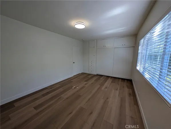 a view of a livingroom with wooden floor and window