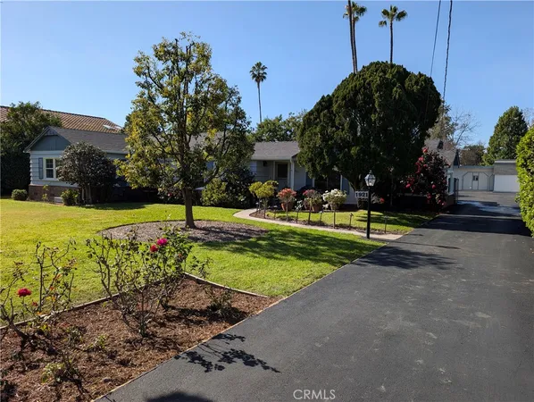 a front view of a house with a flower garden