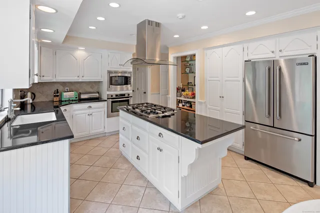 a kitchen with granite countertop a sink stainless steel appliances and cabinets