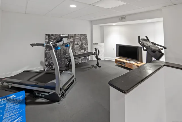 a room with gym equipment and a flat screen tv