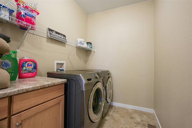 12442 Carmel Ridge Road Colorado Springs, CO 80921 - Photo 29 of 50 Washroom with cabinets and independent washer and dryer