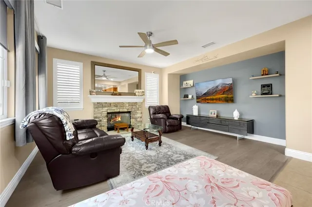 a living room with furniture a fireplace and a flat screen tv