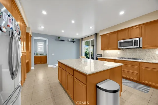 a kitchen with stainless steel appliances granite countertop a sink a stove a refrigerator and a microwave