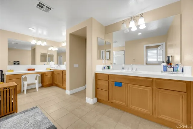 a large bathroom with a double vanity sink a large mirror and a bathtub