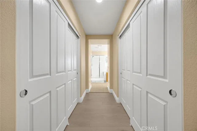 a view of a hallway with white walls and white door
