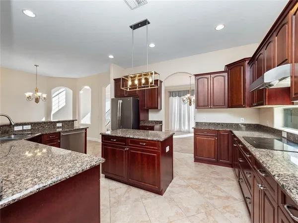 a kitchen with stainless steel appliances granite countertop a sink stove and refrigerator