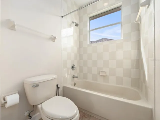 an empty room with a window and a ceiling fan