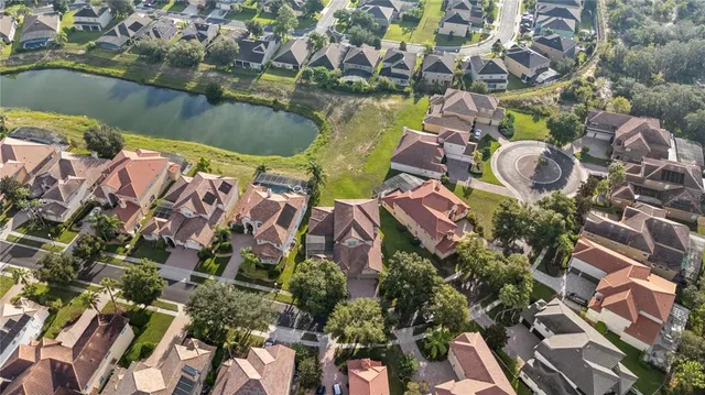 an aerial view of residential houses with outdoor space and lake view