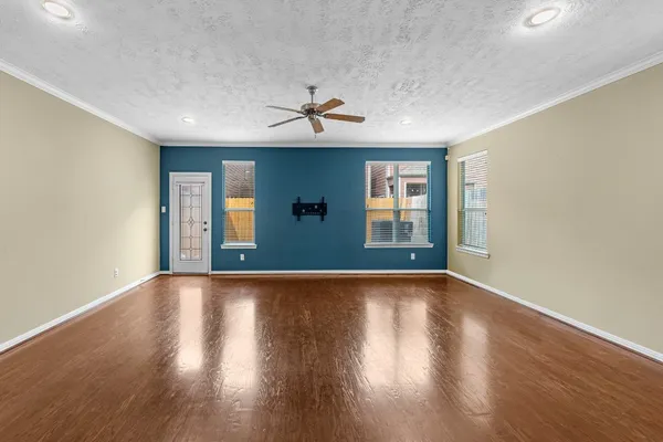 a view of an empty room with window and wooden floor