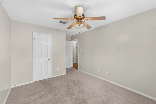 a view of an empty room with a window and a fan