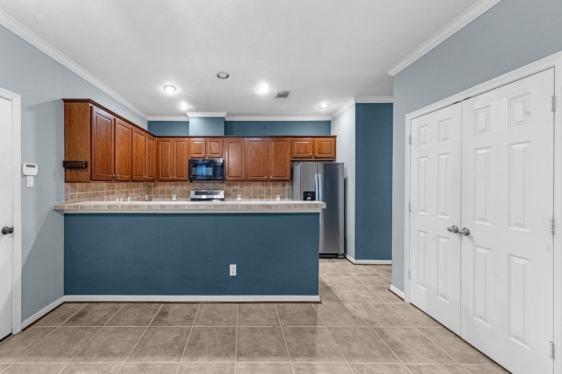 5228 Larkin Street Houston, TX 77007 - Photo 7 of 29 a kitchen with granite countertop a refrigerator and cabinets