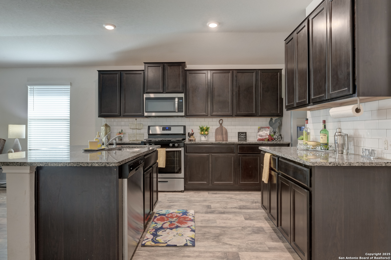 29624 Copper Crossing Bulverde, TX 78163 - Photo 5 of 33 a kitchen with granite countertop stainless steel appliances and wooden cabinets