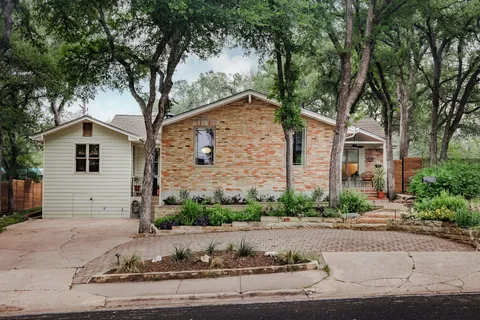 a front view of a house with garden and plants