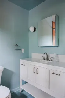 a bathroom with a toilet sink and mirror