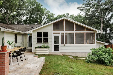 a house view with a sitting space garden and wooden bench