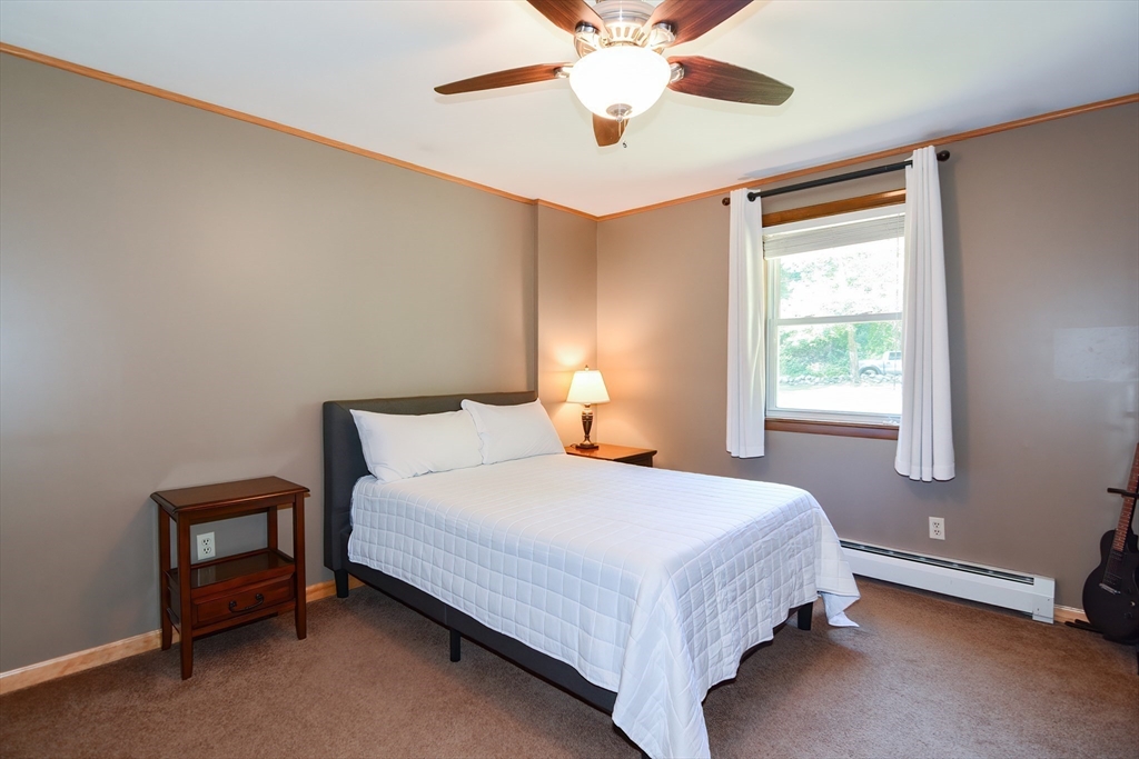 100 Cutler Road Warren, MA 01083 - Photo 22 of 42 a bedroom with a bed lamp and a chandelier