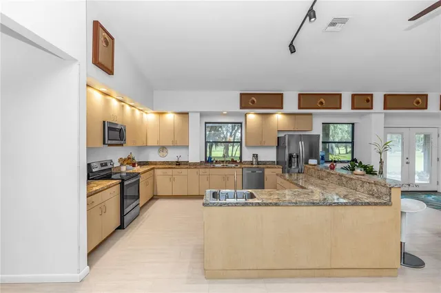 a bathroom with a granite countertop sink a mirror and shower
