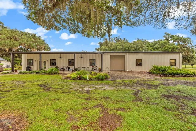 a living room with furniture kitchen view and a chandelier