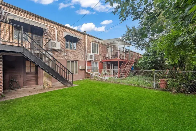 a view of a house with a yard and sitting area