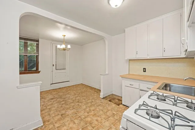 a kitchen with a stove and white cabinets