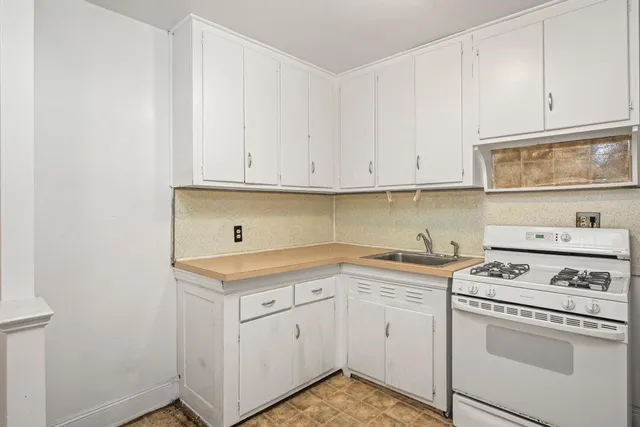 a kitchen with white cabinets and white appliances