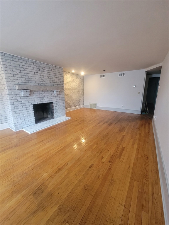 74 Temple Street, Unit 1 Springfield, MA 01105 - Photo 5 of 11 a view of empty room with wooden floor and fireplace