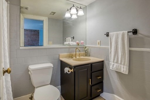 74 Temple Street, Unit 1 Springfield, MA 01105 - Photo 8 of 11 a bathroom with a toilet sink and mirror